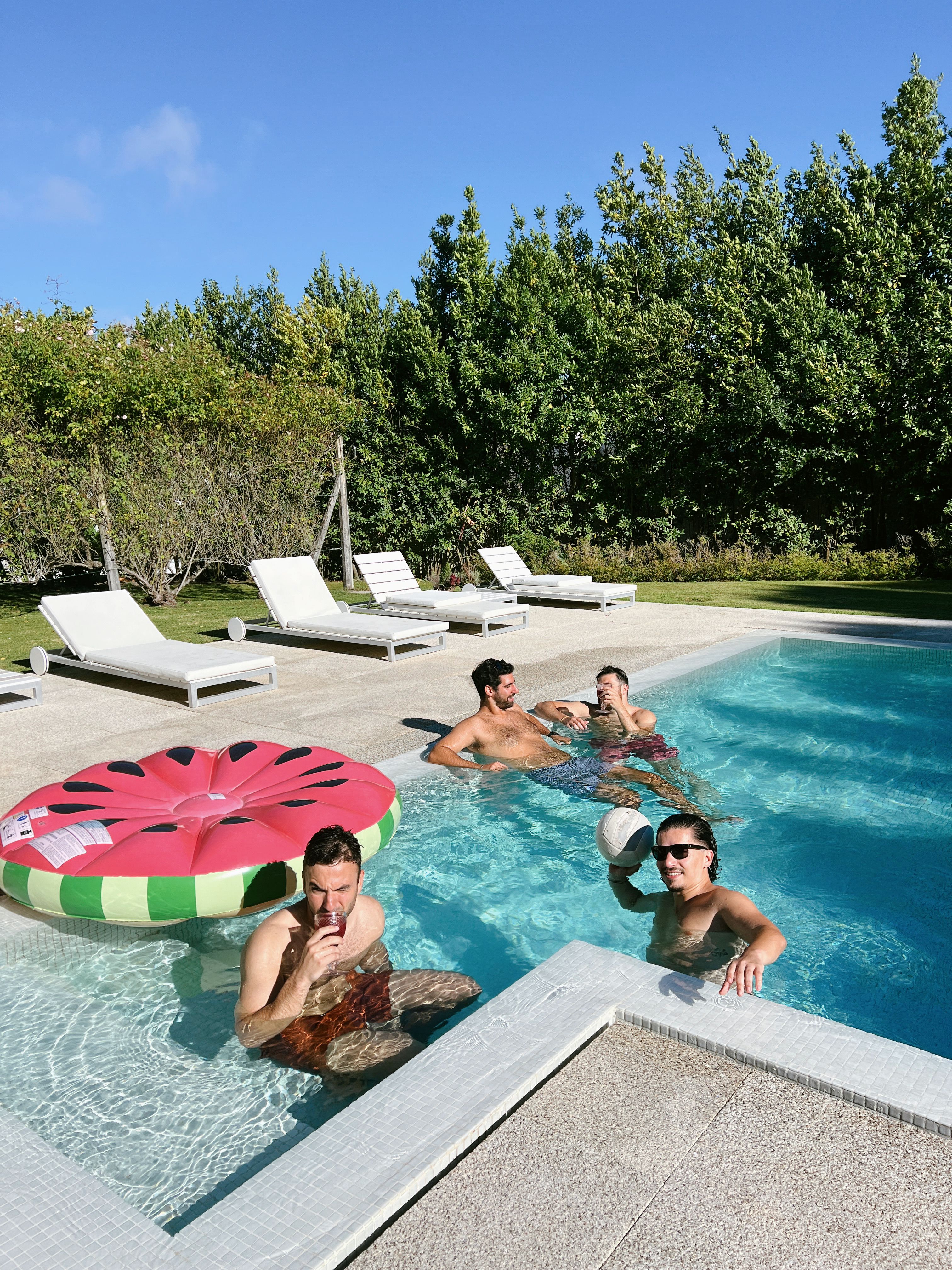 A group of people in a pool with inflatable watermelon · Free Stock Photo