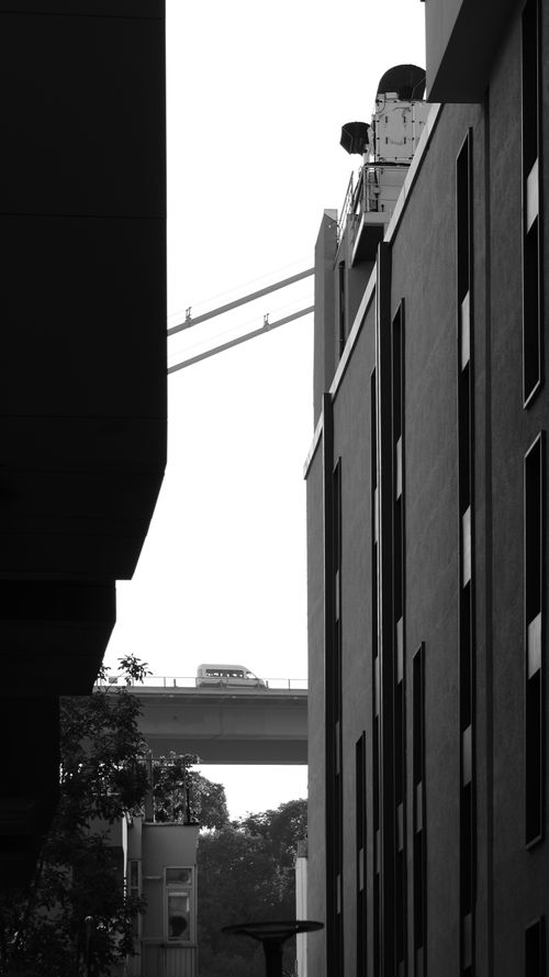 Free Moody black and white cityscape with tall buildings and bridge in the background. Stock Photo