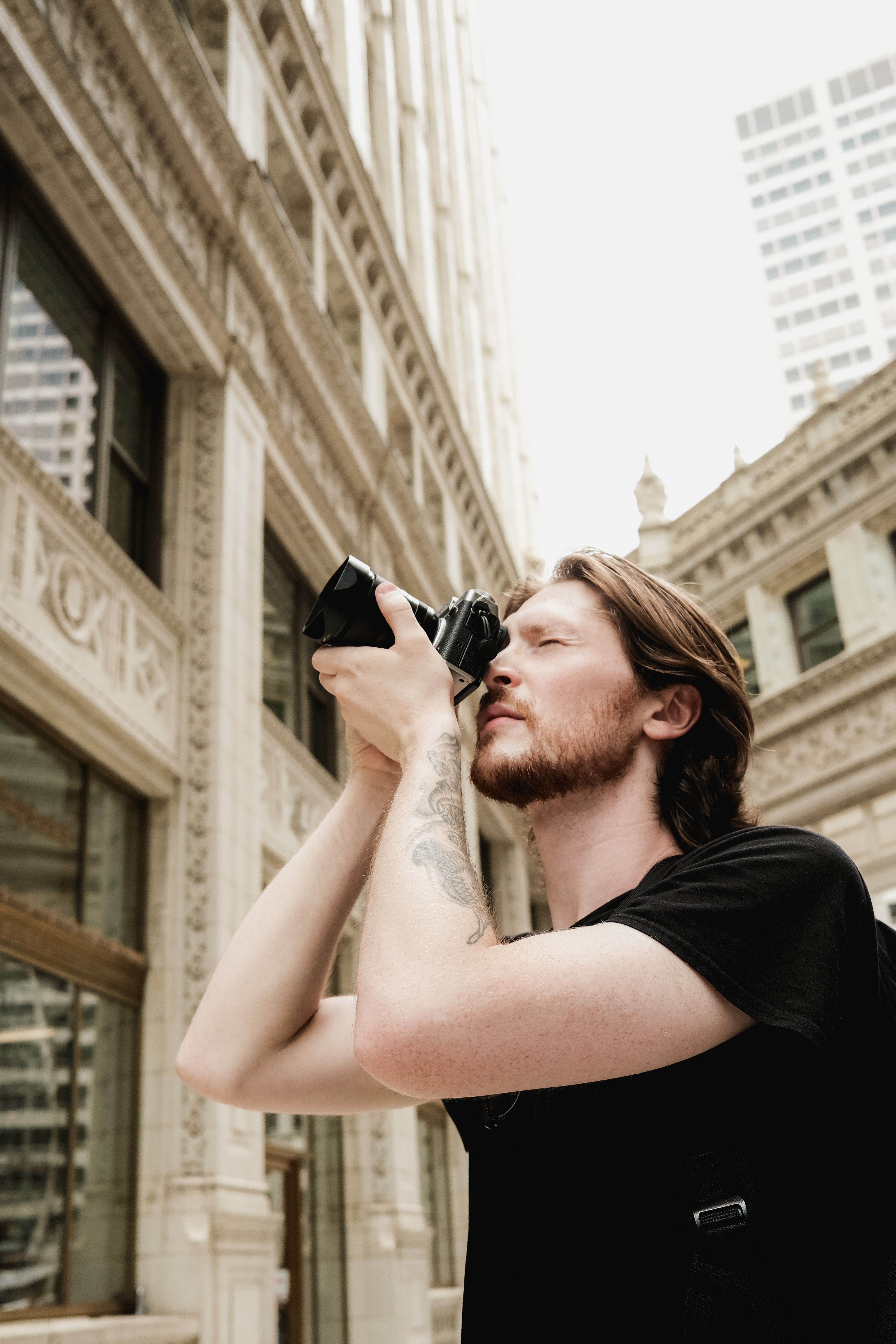 A man photographing the cityscape, focusing on urban architecture and design.