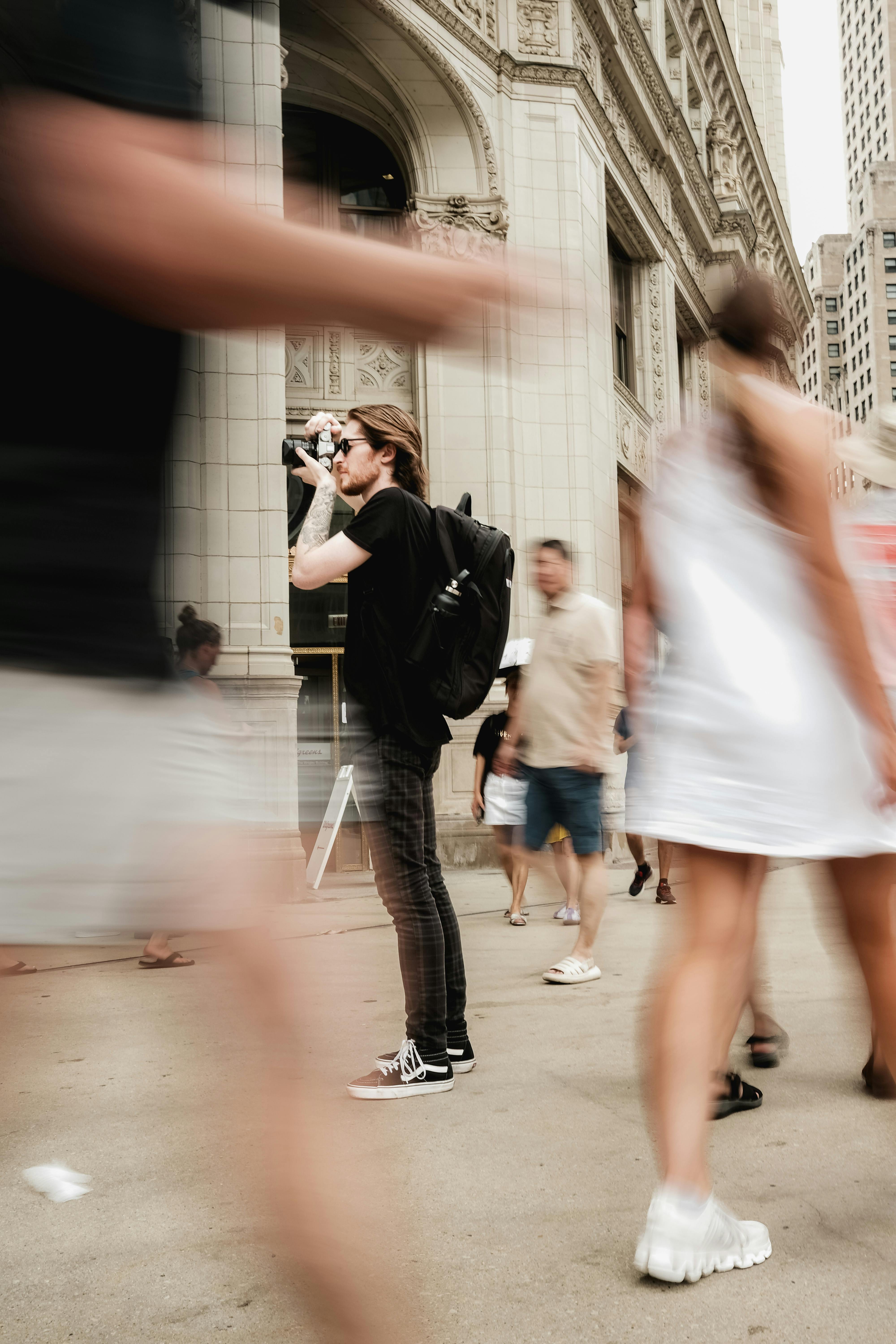 Dynamic motion blur captures city life as a photographer works in lively urban Chicago.