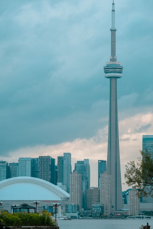 Free View of Toronto skyline featuring the iconic CN Tower under a cloudy sky. Stock Photo