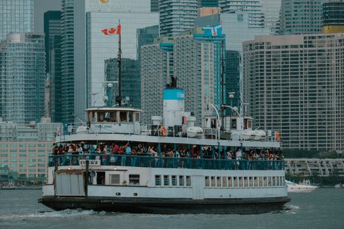 Free A bustling ferry with passengers sails against the backdrop of Toronto's iconic skyline. Stock Photo