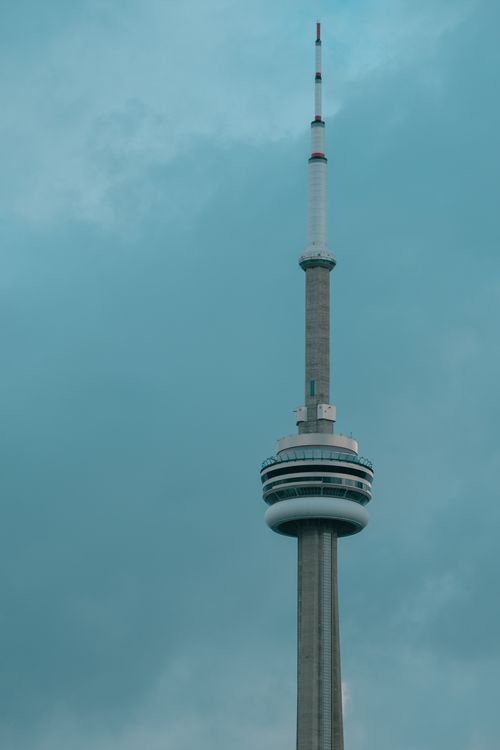 Free The CN Tower rises against a dramatic cloudy sky in Toronto, Canada, showcasing modern architecture. Stock Photo