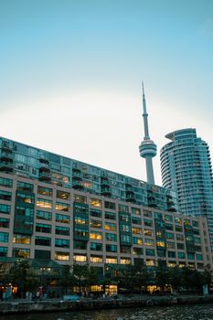 Stunning view of CN Tower with Toronto's modern skyline and waterfront at dusk.