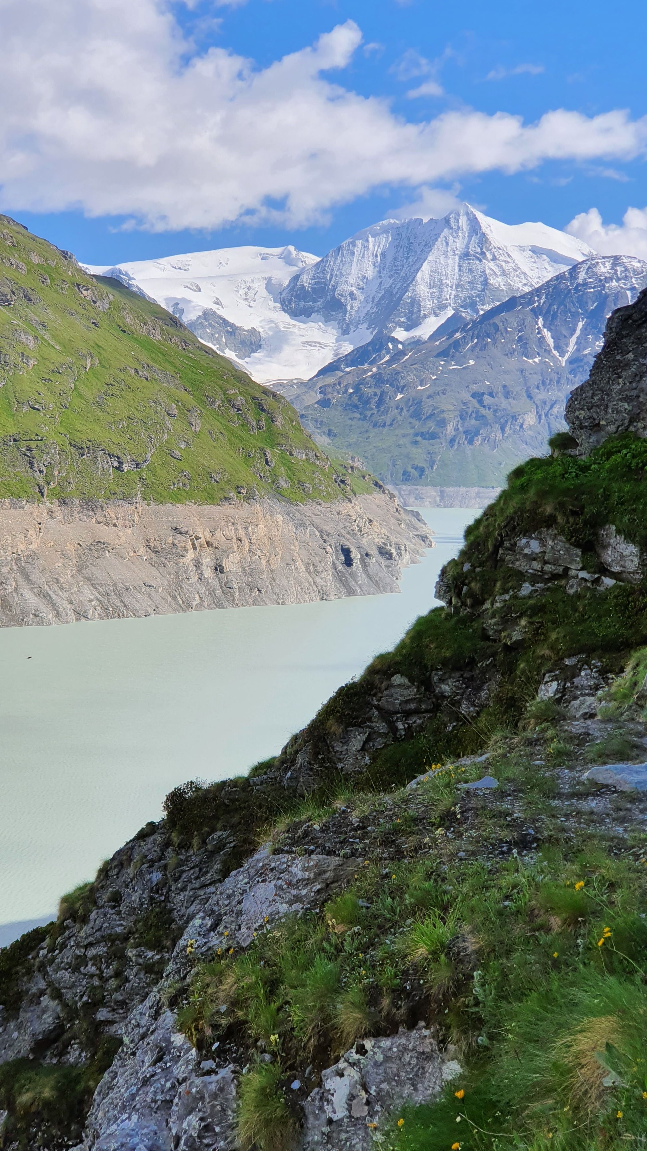 Stunning view of snow-capped Alps and serene lake in Hérémence, Switzerland. Perfect for nature lovers.