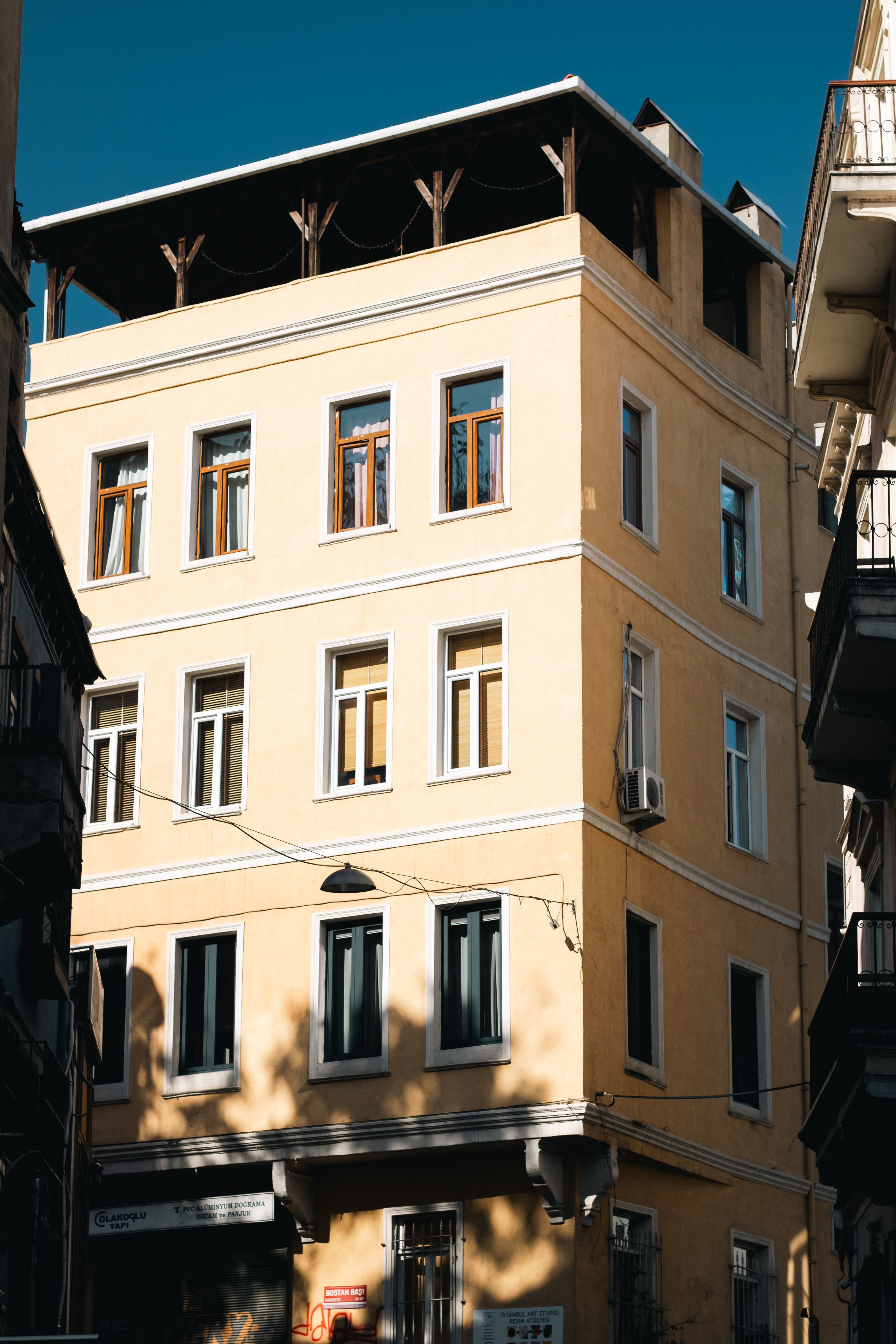 Sunlit urban apartment building with balconies and classic architecture, ideal for travel and city themes.