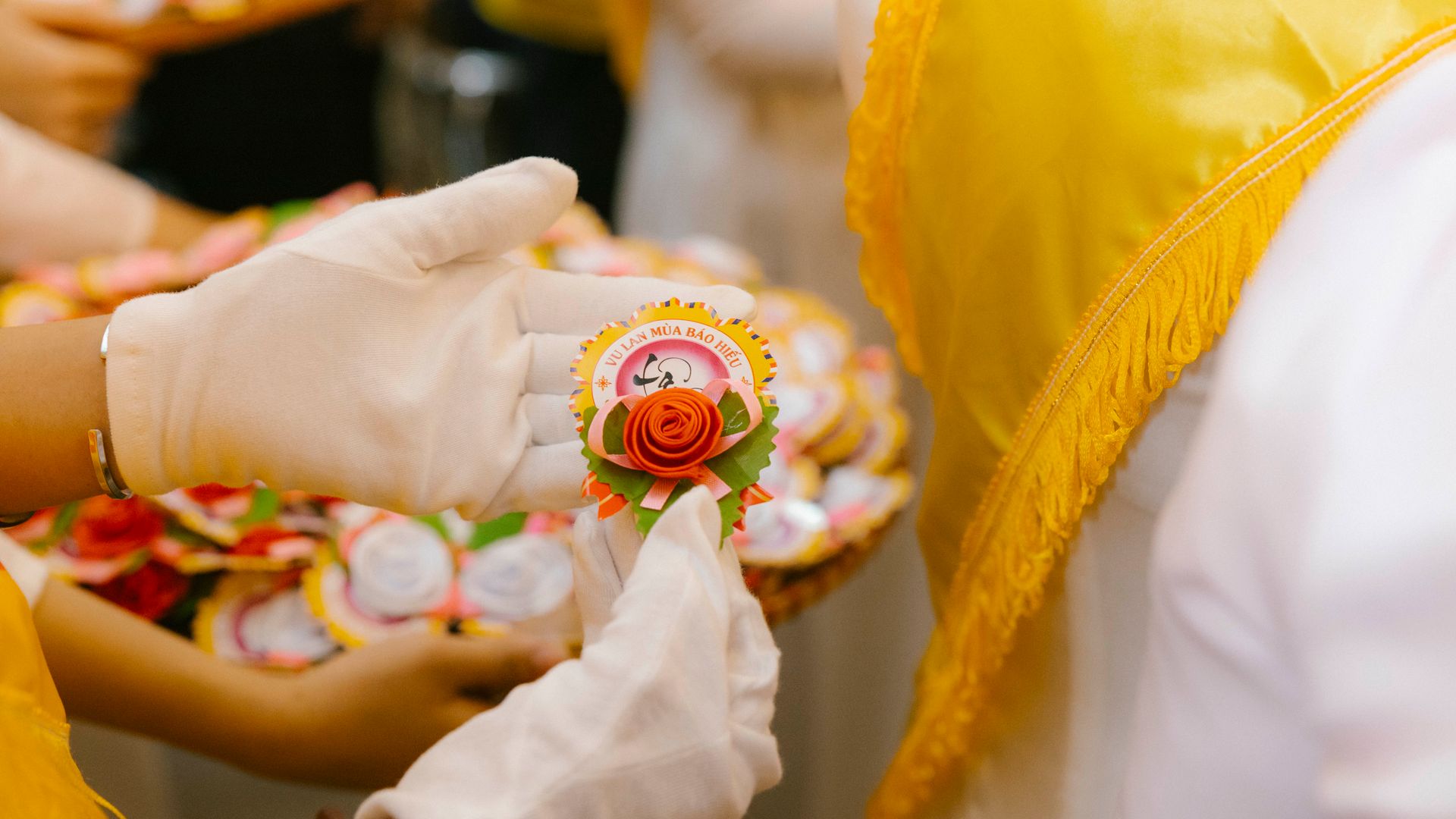 Badge Printing: Your Ultimate Guide to Custom Identification 7 Gloved hands exchanging a decorative badge during a cultural ceremony indoors — badge printing