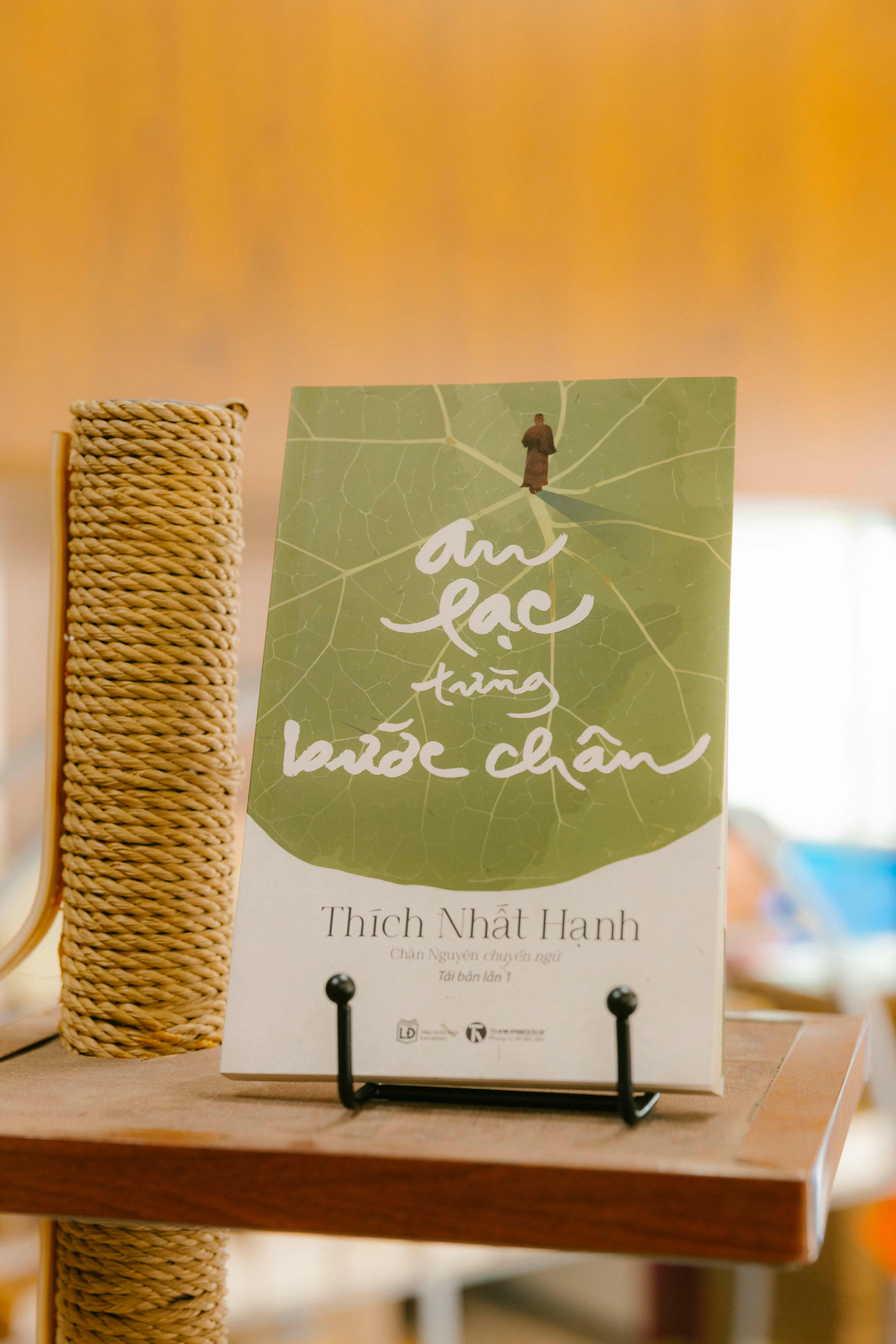 a book on a table with a leaf on it