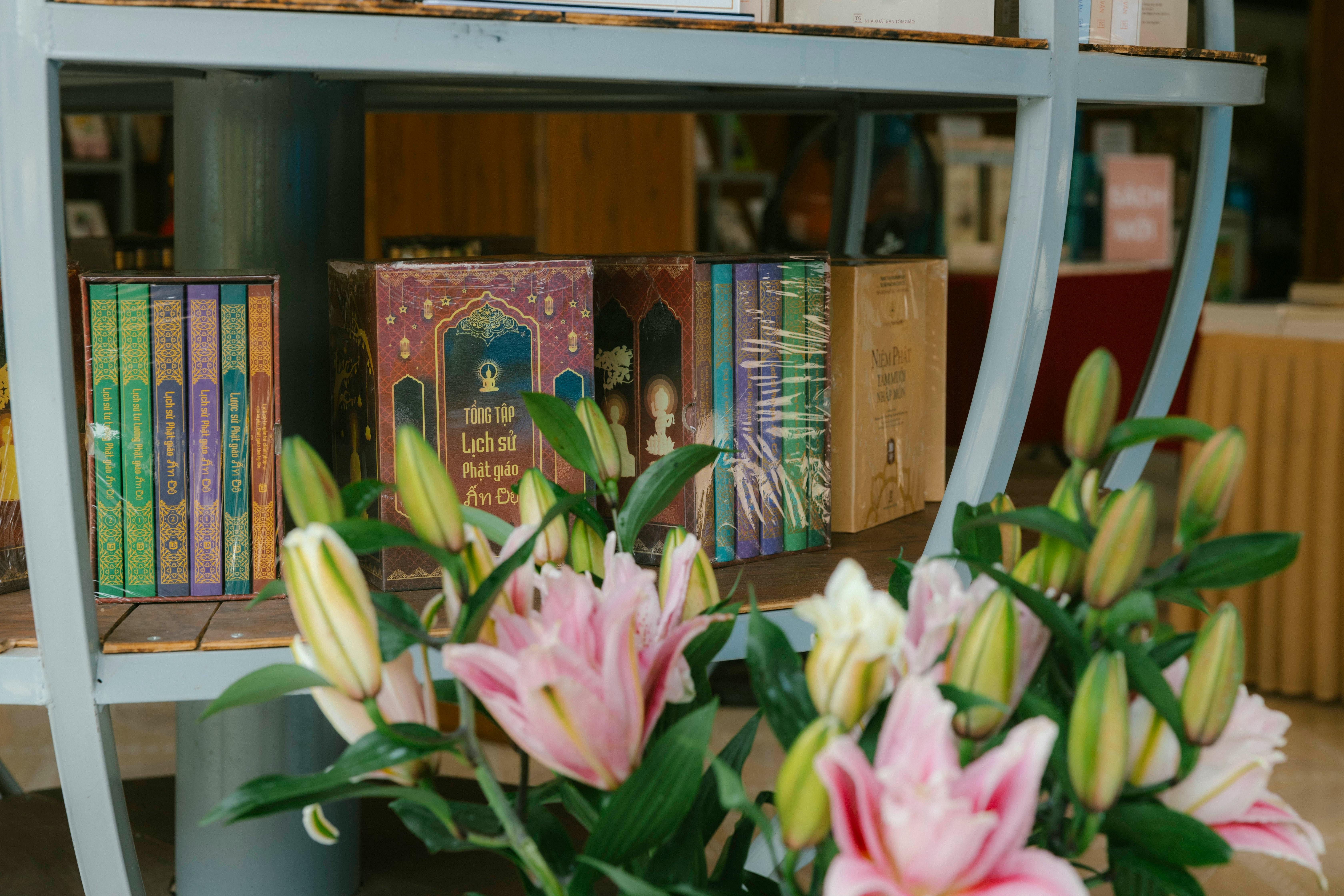 a flower arrangement in front of books on a shelf