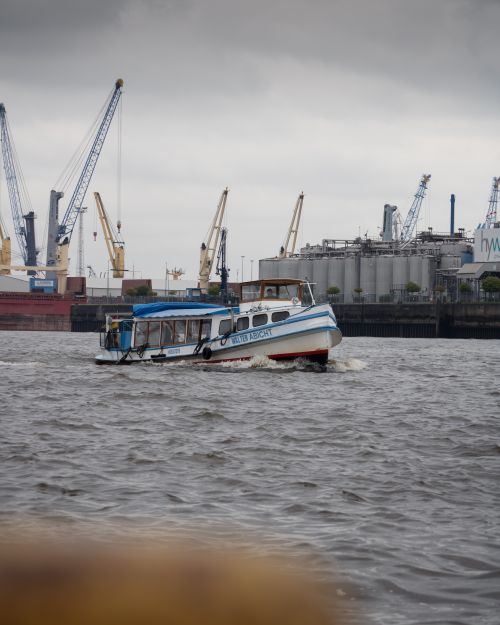 Free A bustling scene of Hamburg Harbor featuring boats and cranes on a cloudy day, showcasing maritime activity. Stock Photo