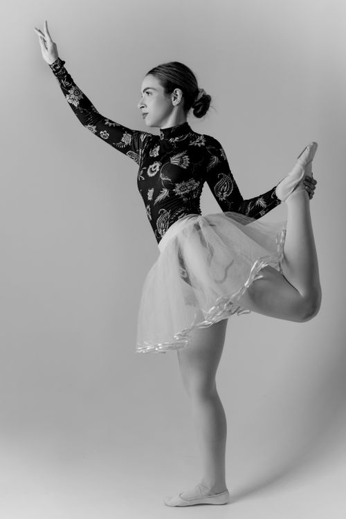 Free Black and white portrait of a young ballerina striking a graceful pose in a studio setting. Stock Photo