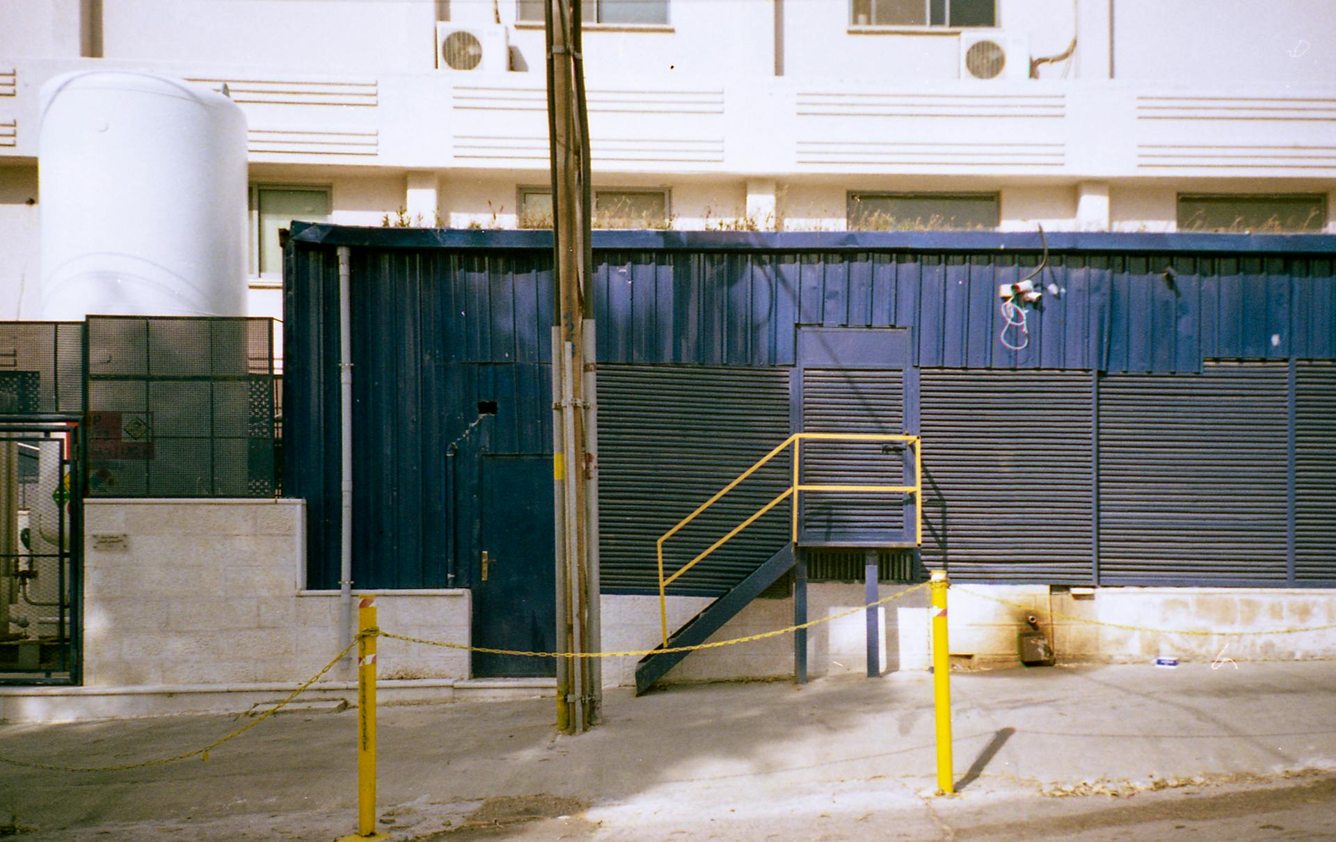 Exterior view of an industrial building with blue metal siding in Amman, Jordan.