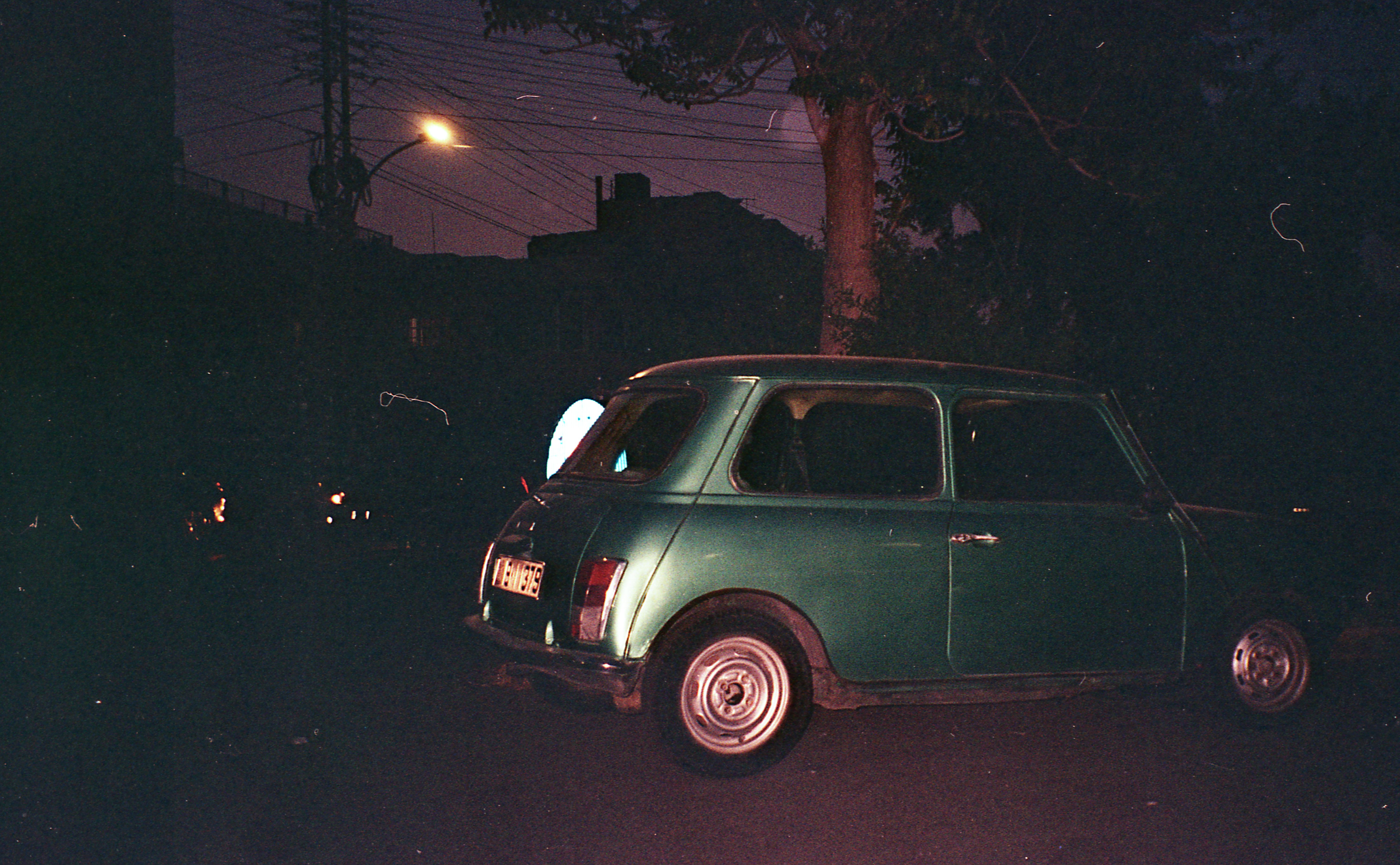 A small green car parked on the side of the road · Free Stock Photo