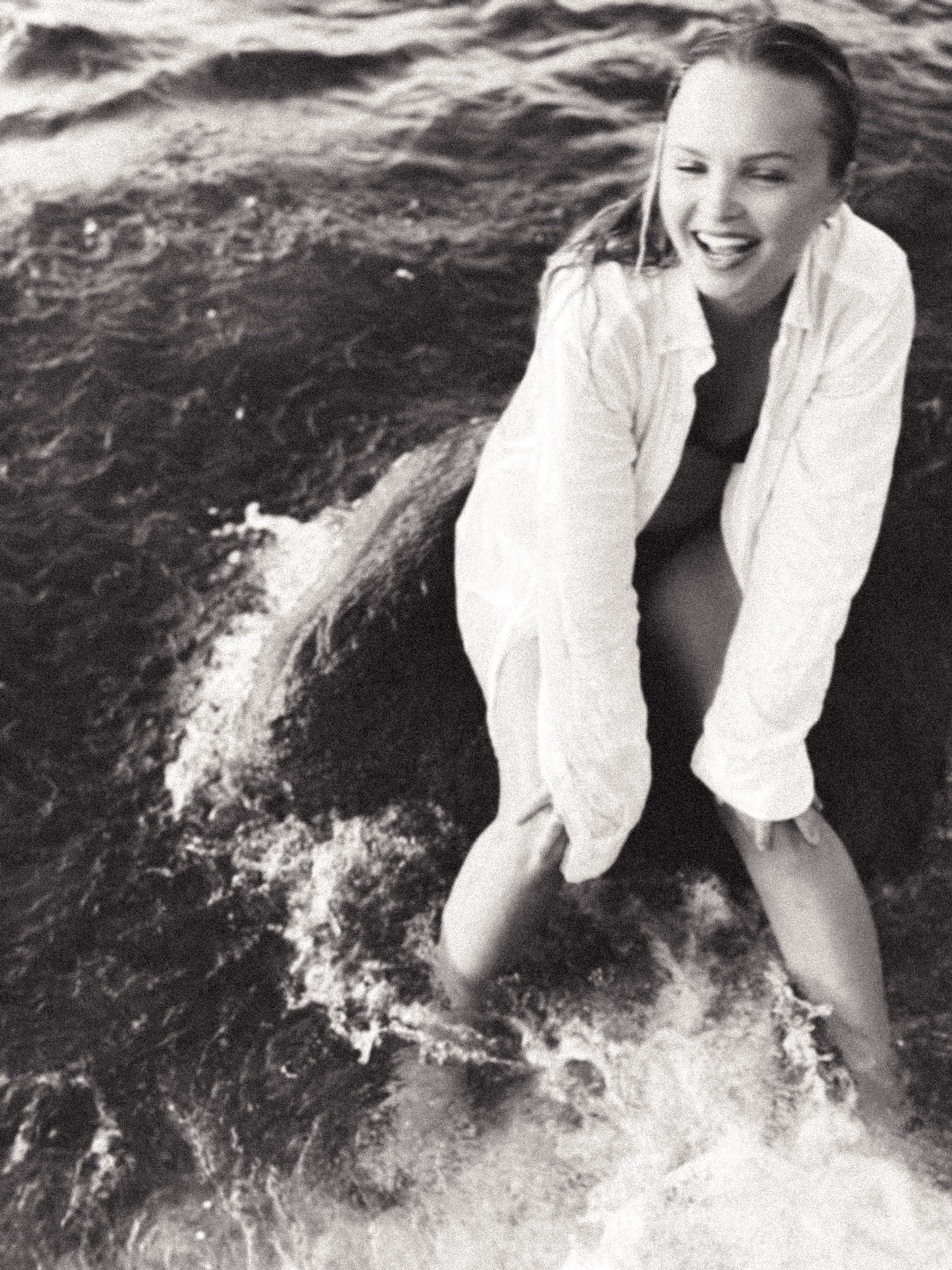 A woman sitting on the beach in the water · Free Stock Photo