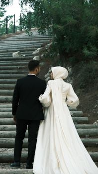 Bride and groom walking up outdoor steps in an intimate wedding moment.