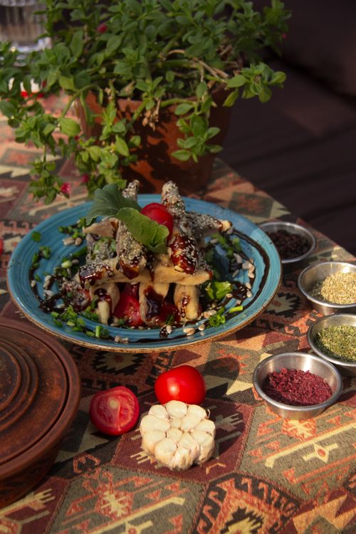 Free Colorful Mediterranean meal with fresh herbs on a patterned tablecloth, perfect for food enthusiasts. Stock Photo