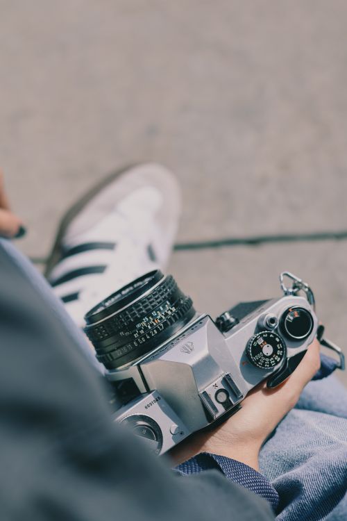 Free A person holding a vintage camera, capturing the essence of nostalgic photography outdoors. Stock Photo
