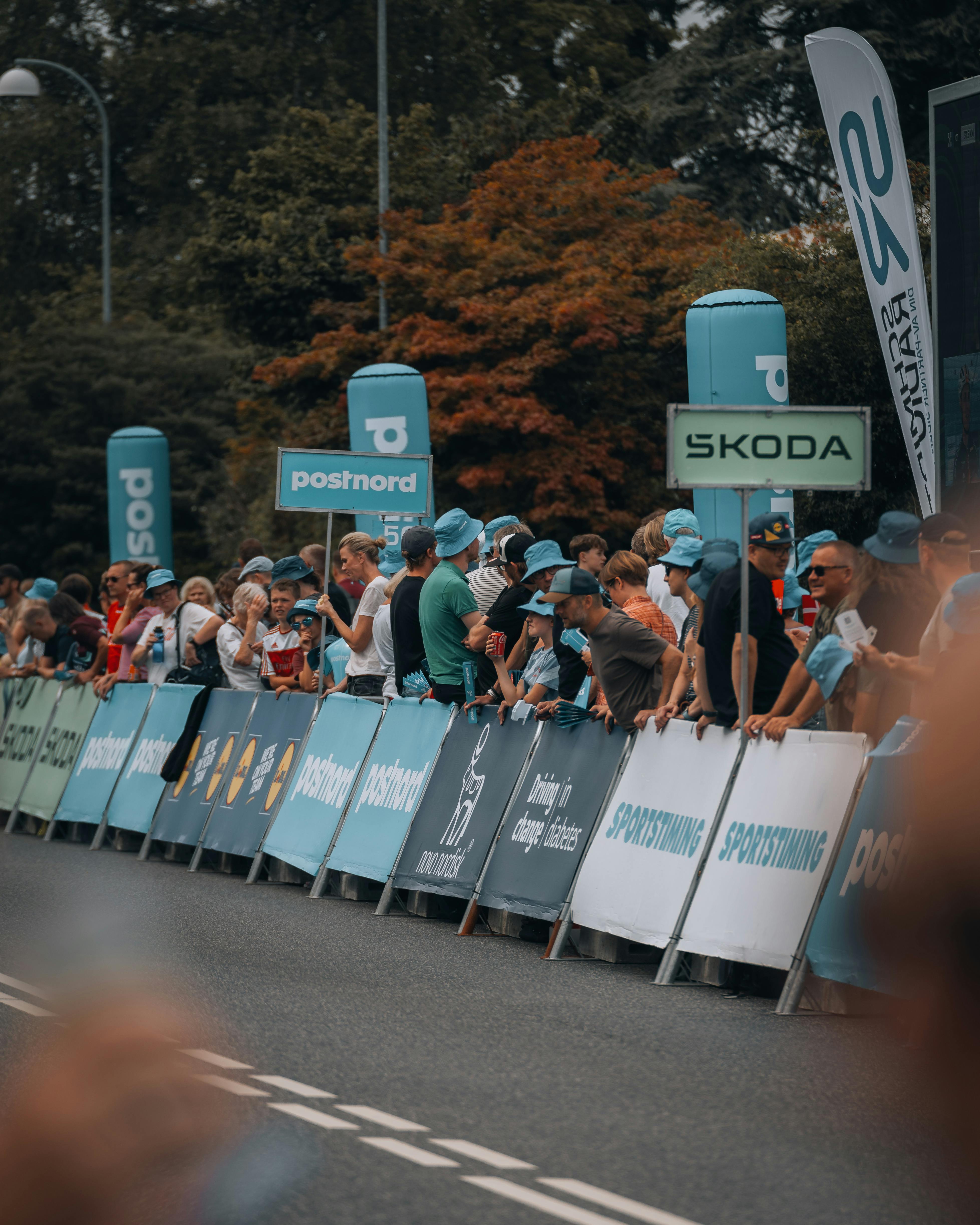 a crowd of people standing behind a barrier