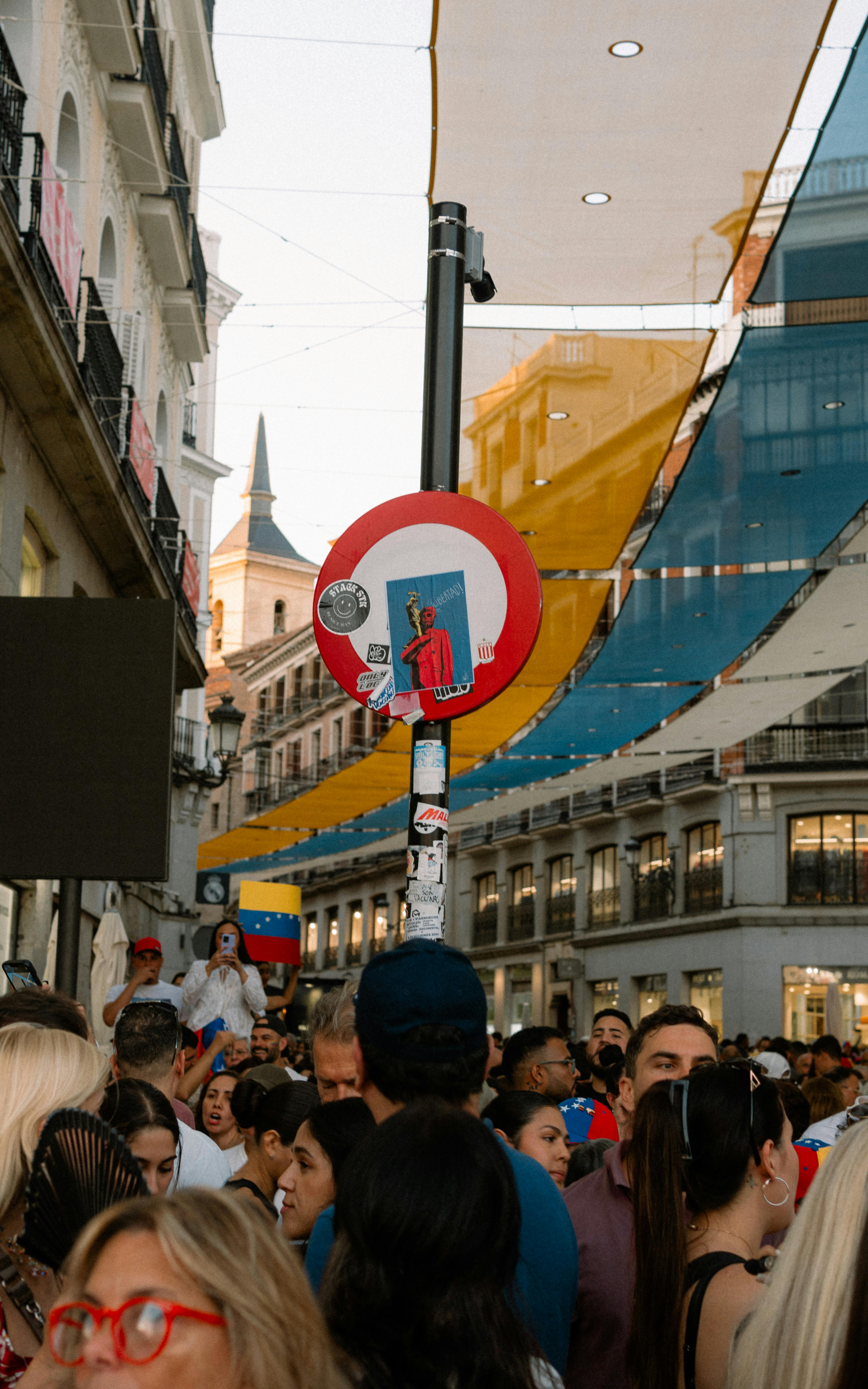 a crowd of people standing in a street with a sign