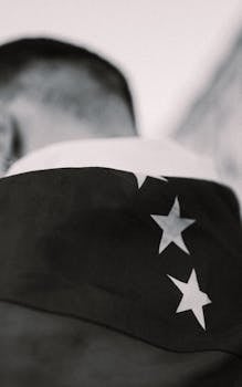 Profile view of an adult draped in a star-studded flag, conveying unity and patriotism.