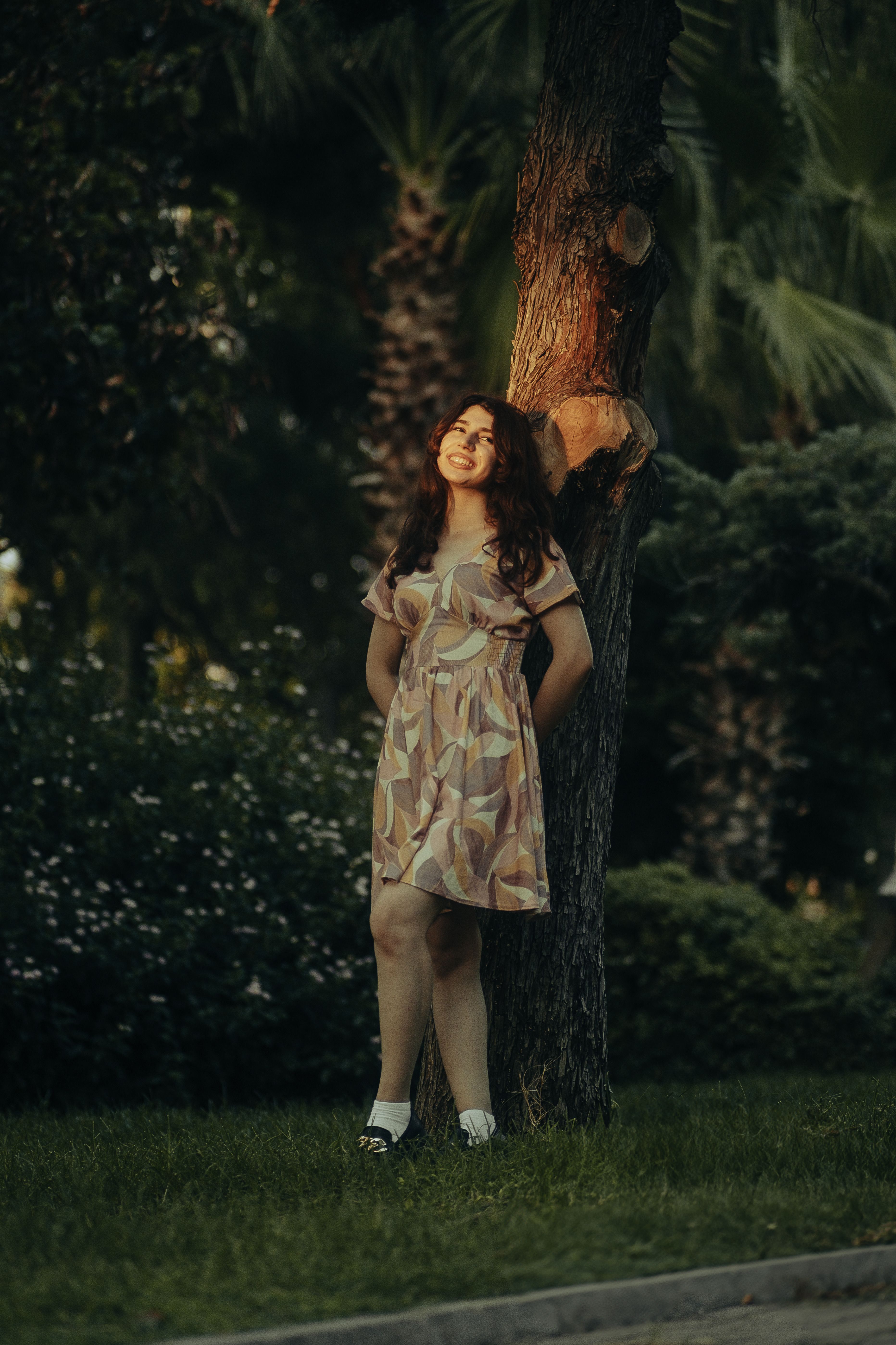A woman standing next to a tree in a dress · Free Stock Photo