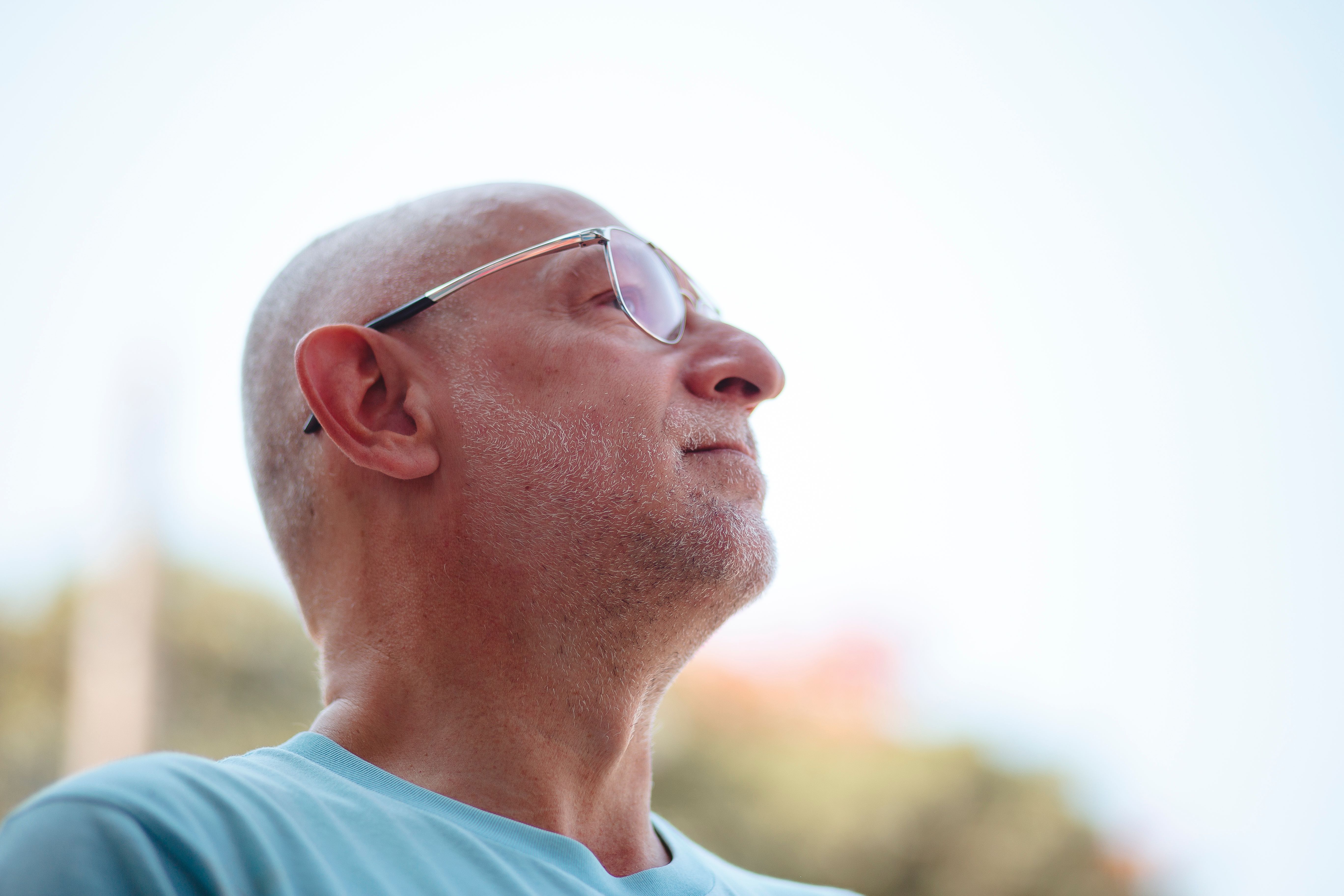 A thoughtful man outdoors considering the symptoms of an enlarged prostate