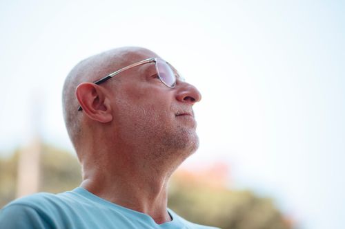 Free Portrait of a thoughtful man wearing sunglasses outdoors on a sunny day in summer. Stock Photo