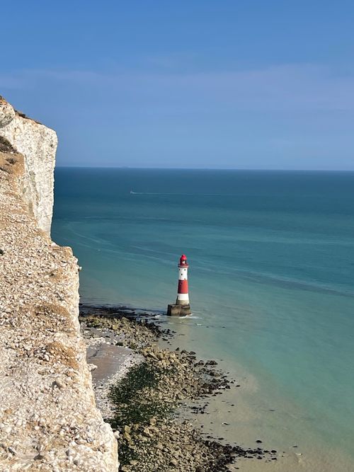 Free Stunning view of Beachy Head Lighthouse with turquoise sea and rocky cliffs in Exceat, UK. Stock Photo