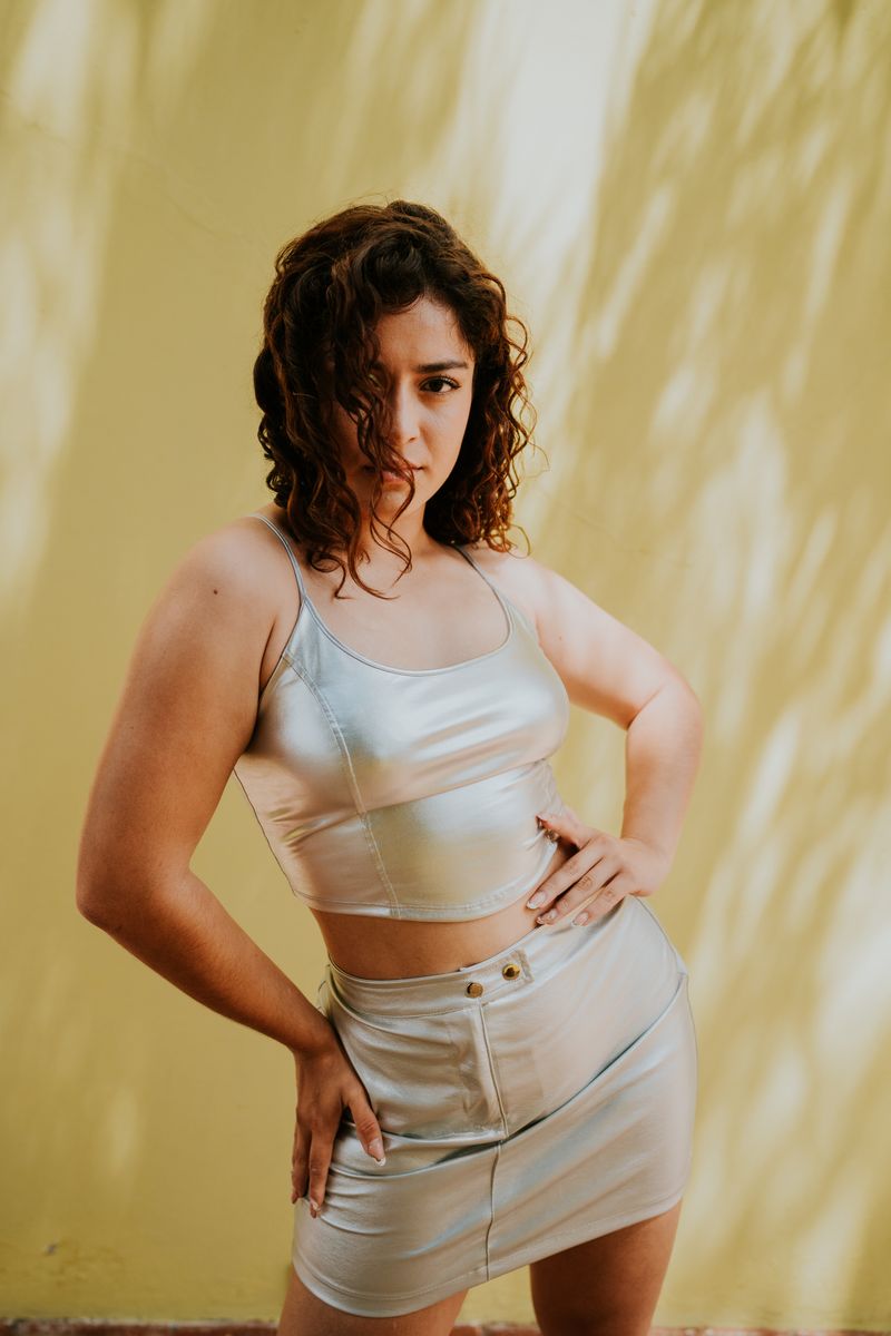 Woman in silver top and skirt posing