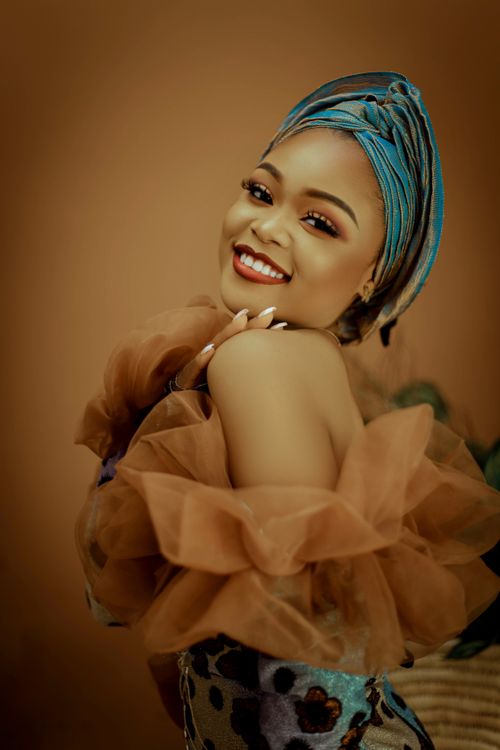 Free A beautiful woman in fashionable attire posing gracefully with a warm smile. Stock Photo