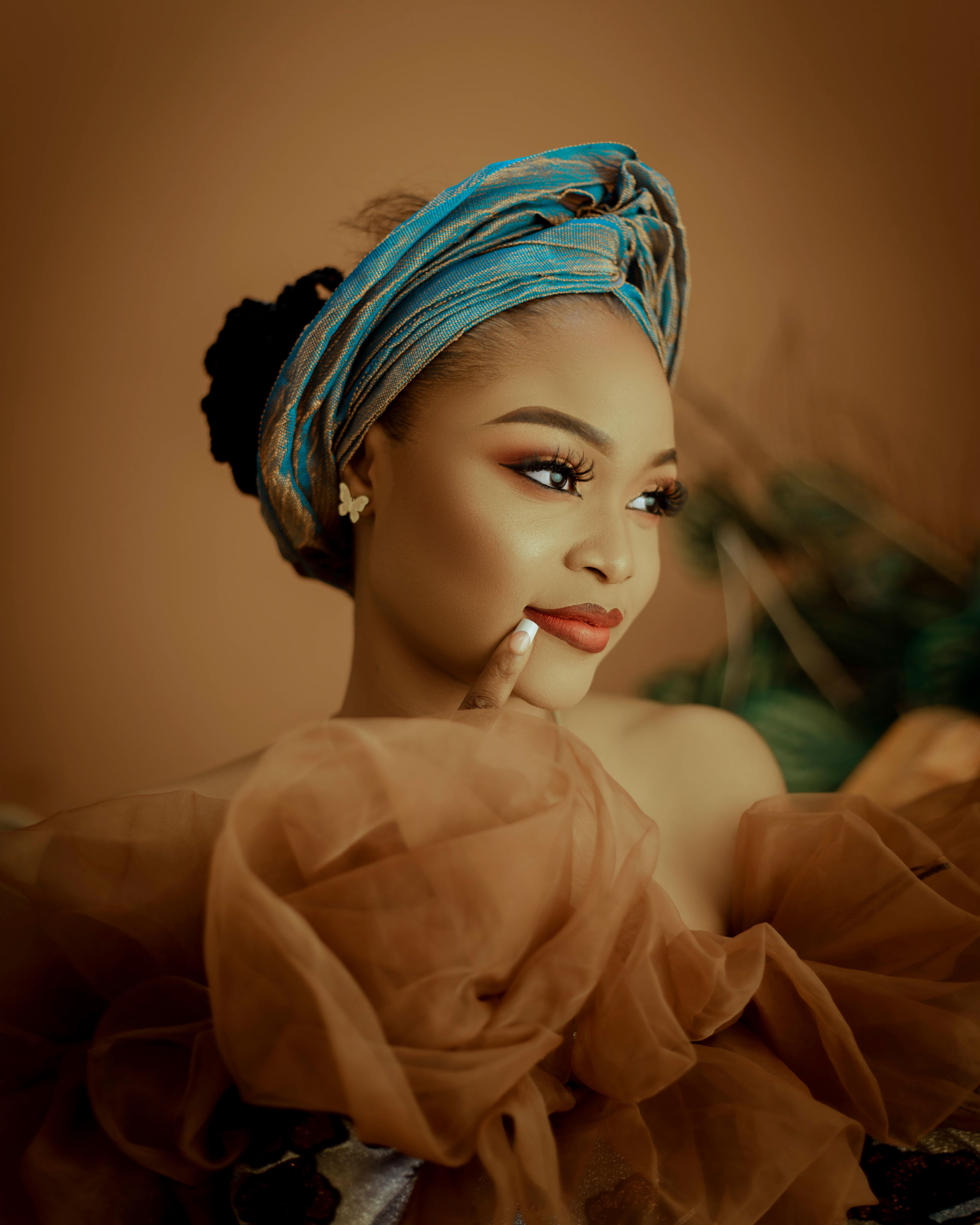 A stunning portrait of a woman in an elegant dress and blue turban, exuding glamour and style.