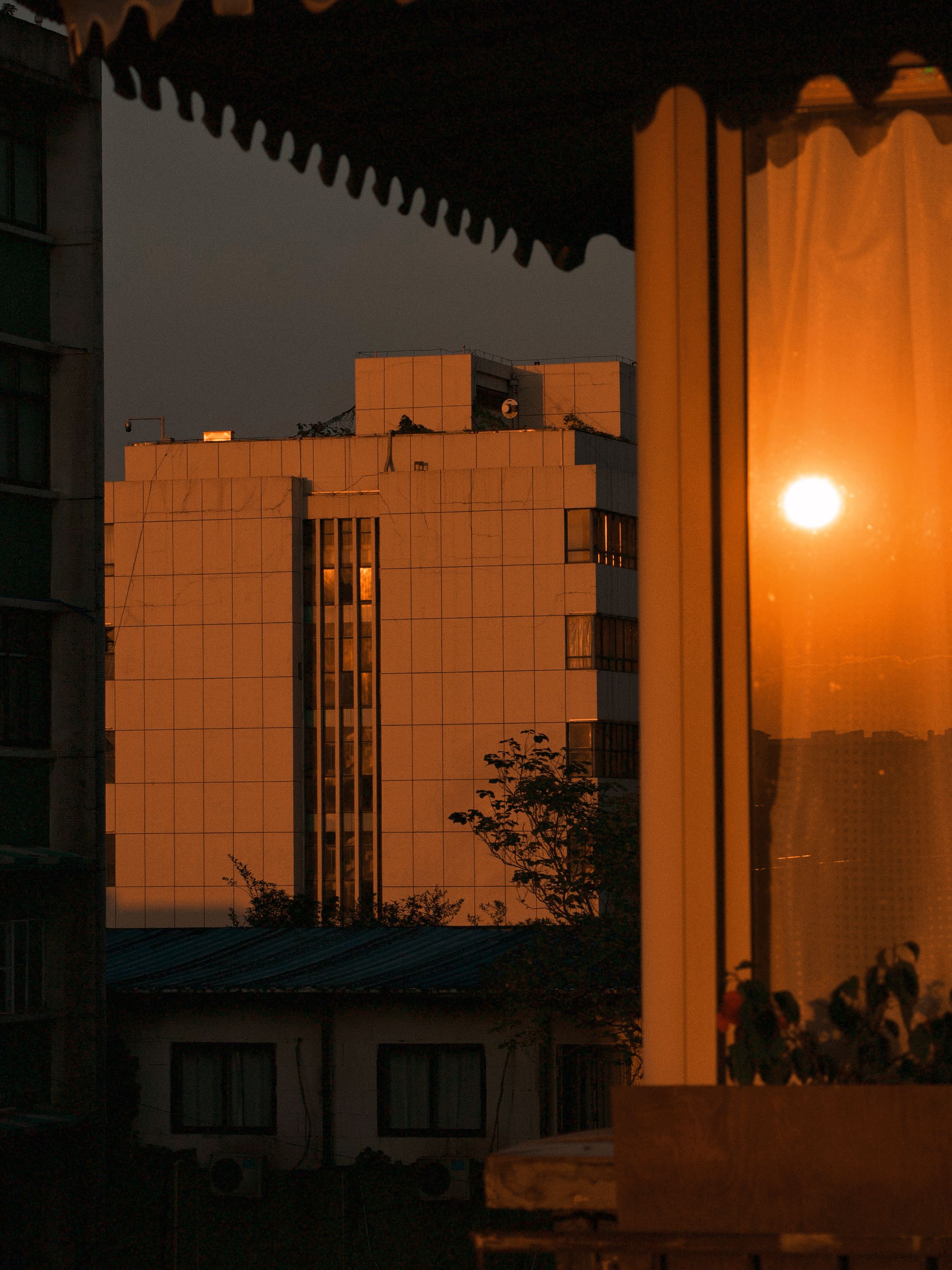 A stunning sunset reflecting on city buildings, creating a warm and dramatic urban scene.