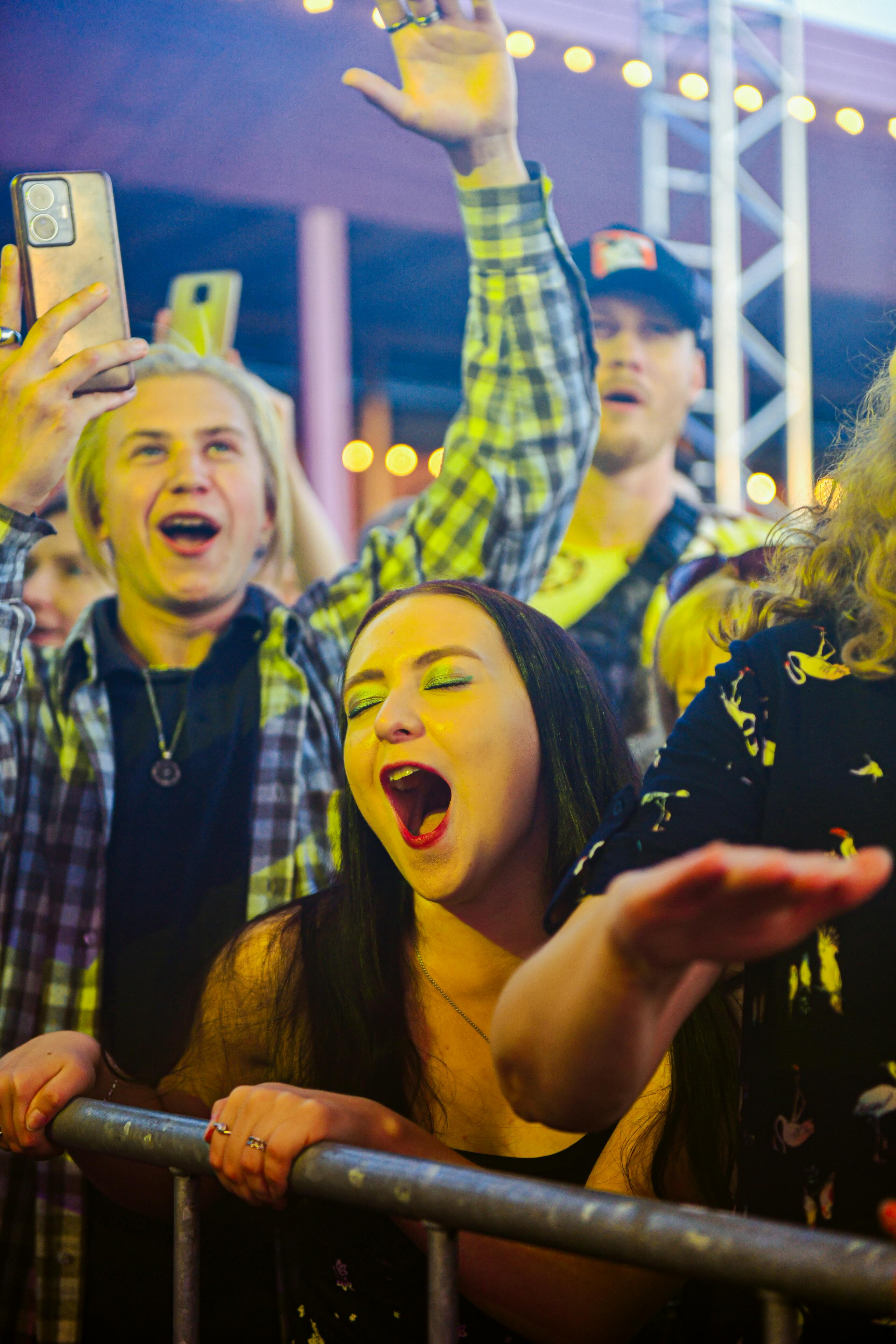 Excited crowd enjoying live music festival, capturing the spirit of celebration and fun.