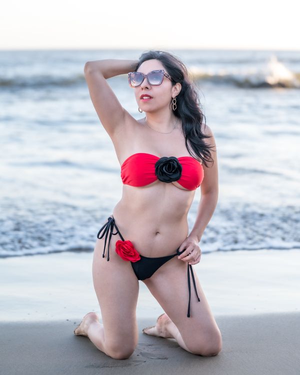 A woman in a red and black bikini on the beach · Free Stock Photo