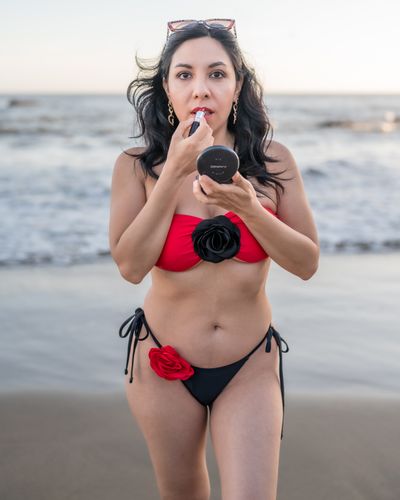 A woman in a red and black bikini on the beach · Free Stock Photo