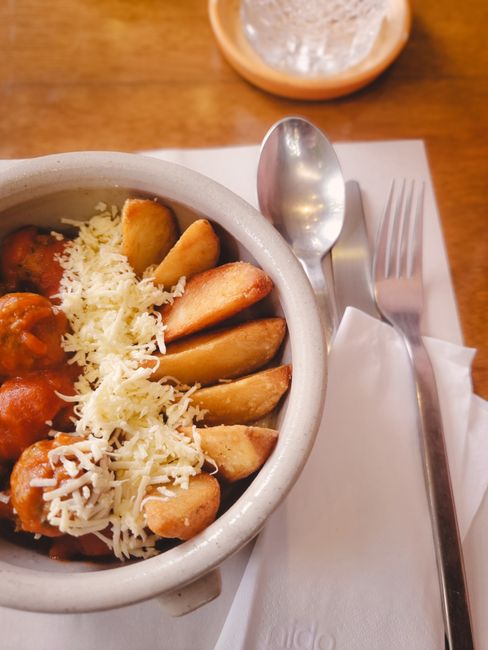 Bucaramanga traditional dish featuring meatballs, potatoes, and cheese, served in a rustic ceramic bowl.
