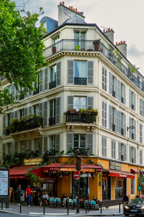 Free A classic Parisian corner building with cafe seating, capturing urban charm and architecture. Stock Photo