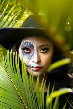 Vibrant portrait featuring a woman with a half-painted artistic face, set in lush tropical foliage.