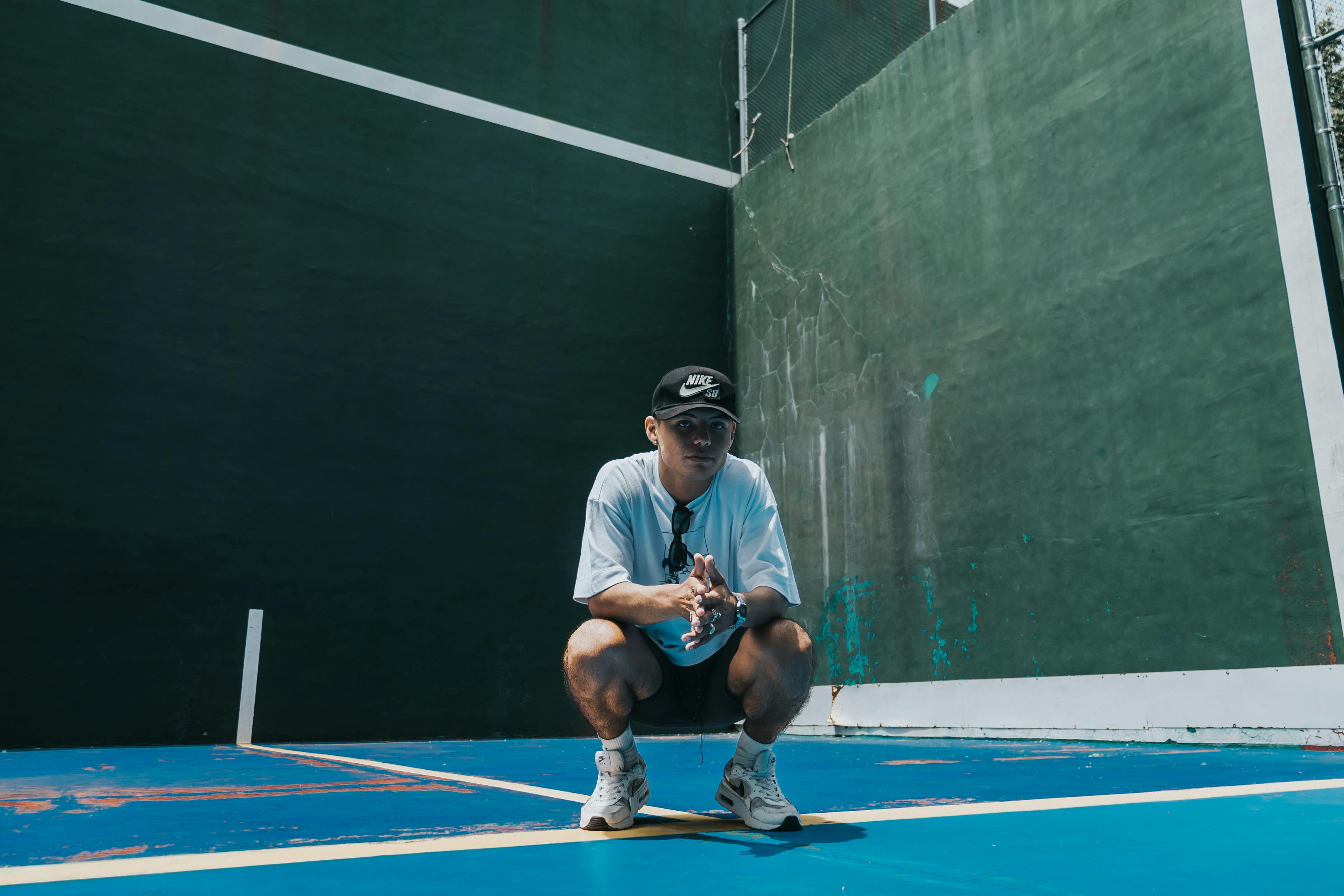 A man crouching down on a tennis court