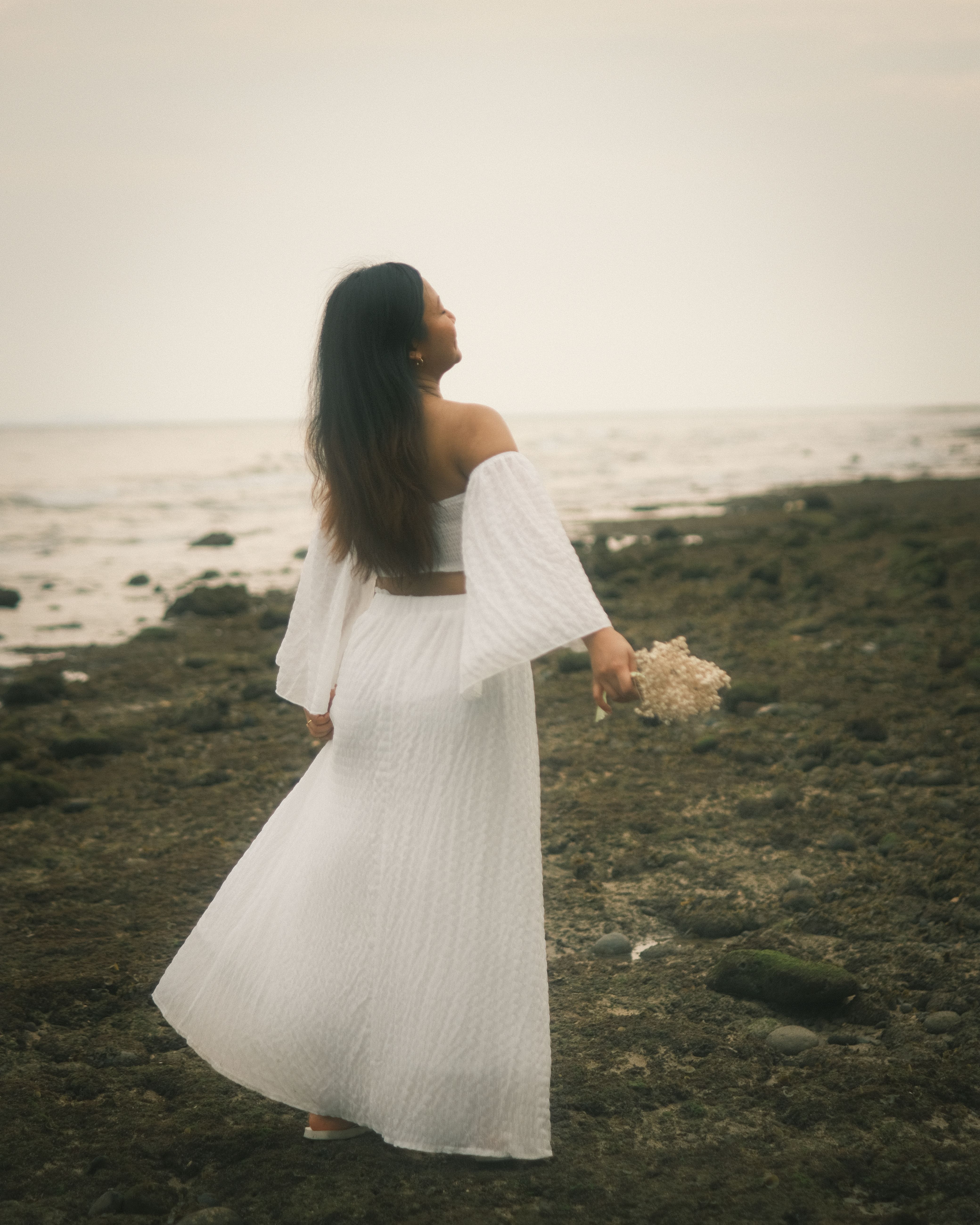 A woman in a white dress standing on the beach · Free Stock Photo