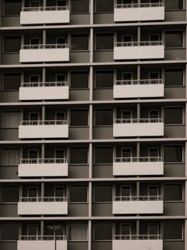 Geometric pattern of a modern apartment facade featuring multiple balconies in black and white.
