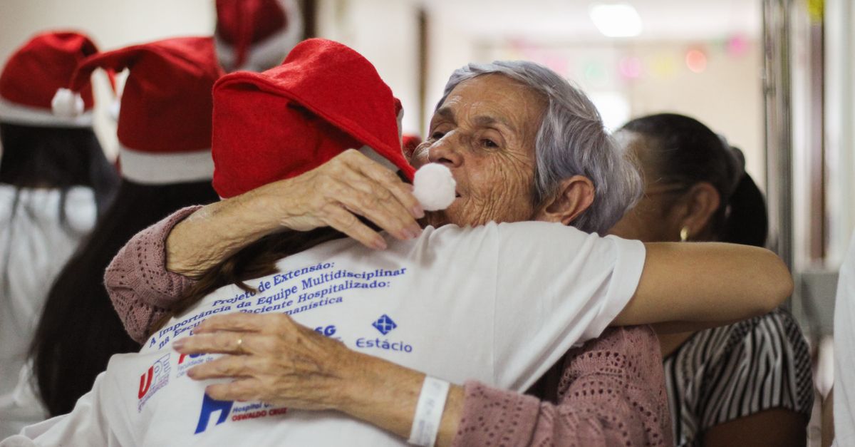 Elderly woman hugging in hospital during festive celebration, fostering connection and joy.