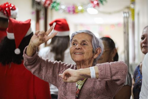 Free Joyful elderly woman celebrating indoors during a festive Christmas event. Stock Photo