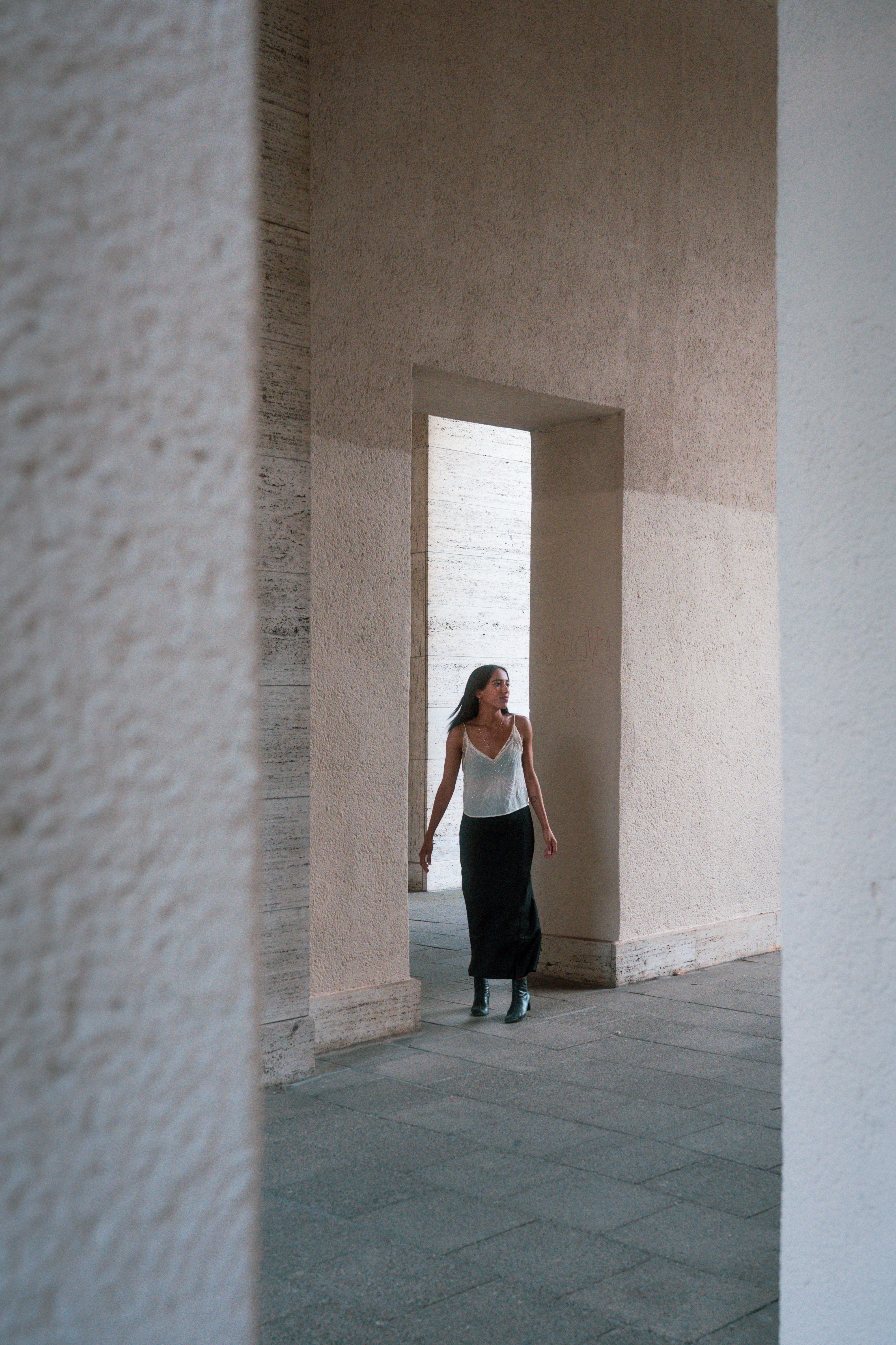 A woman walking through a doorway in a building · Free Stock Photo