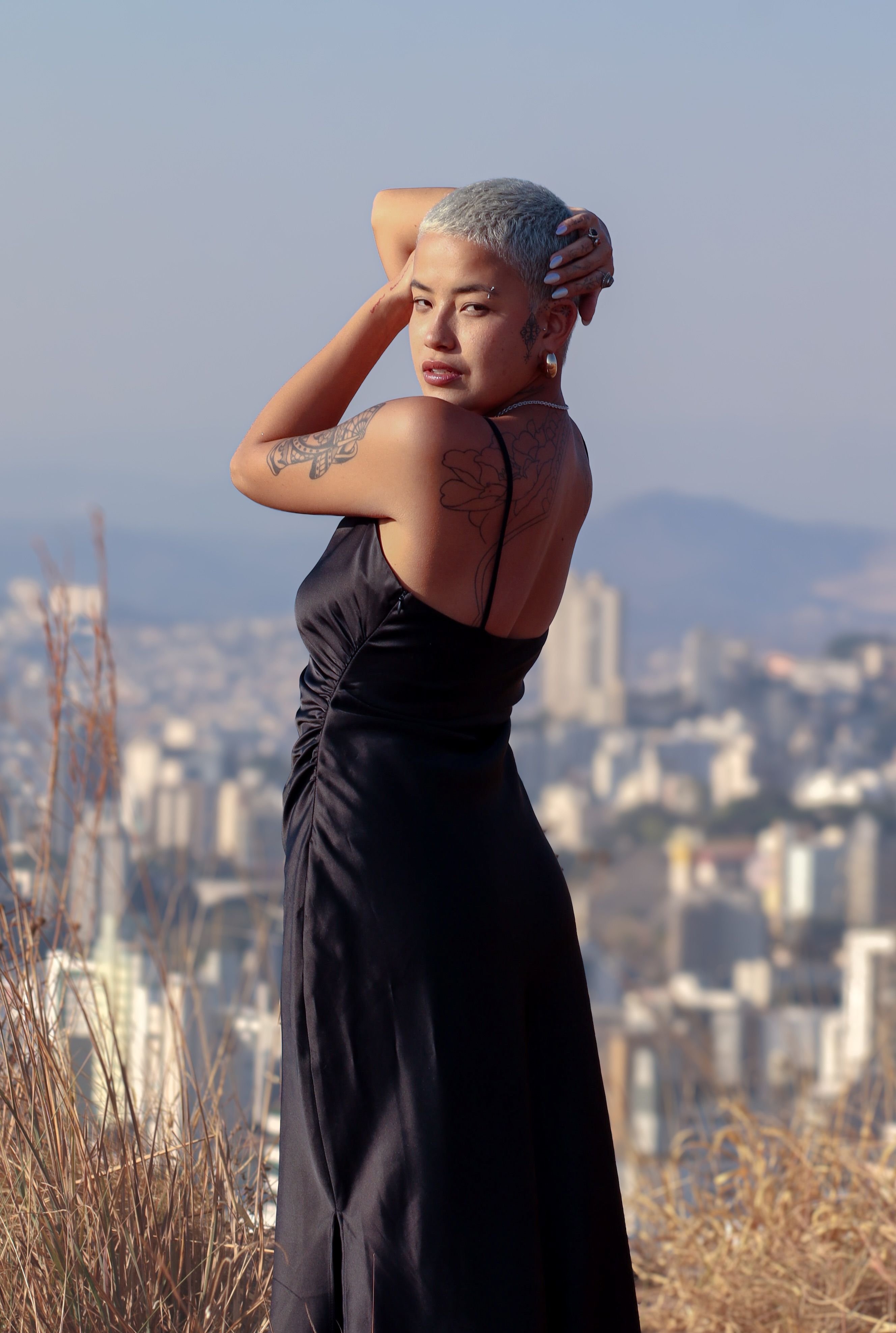 A woman with grey hair posing in front of a city · Free Stock Photo