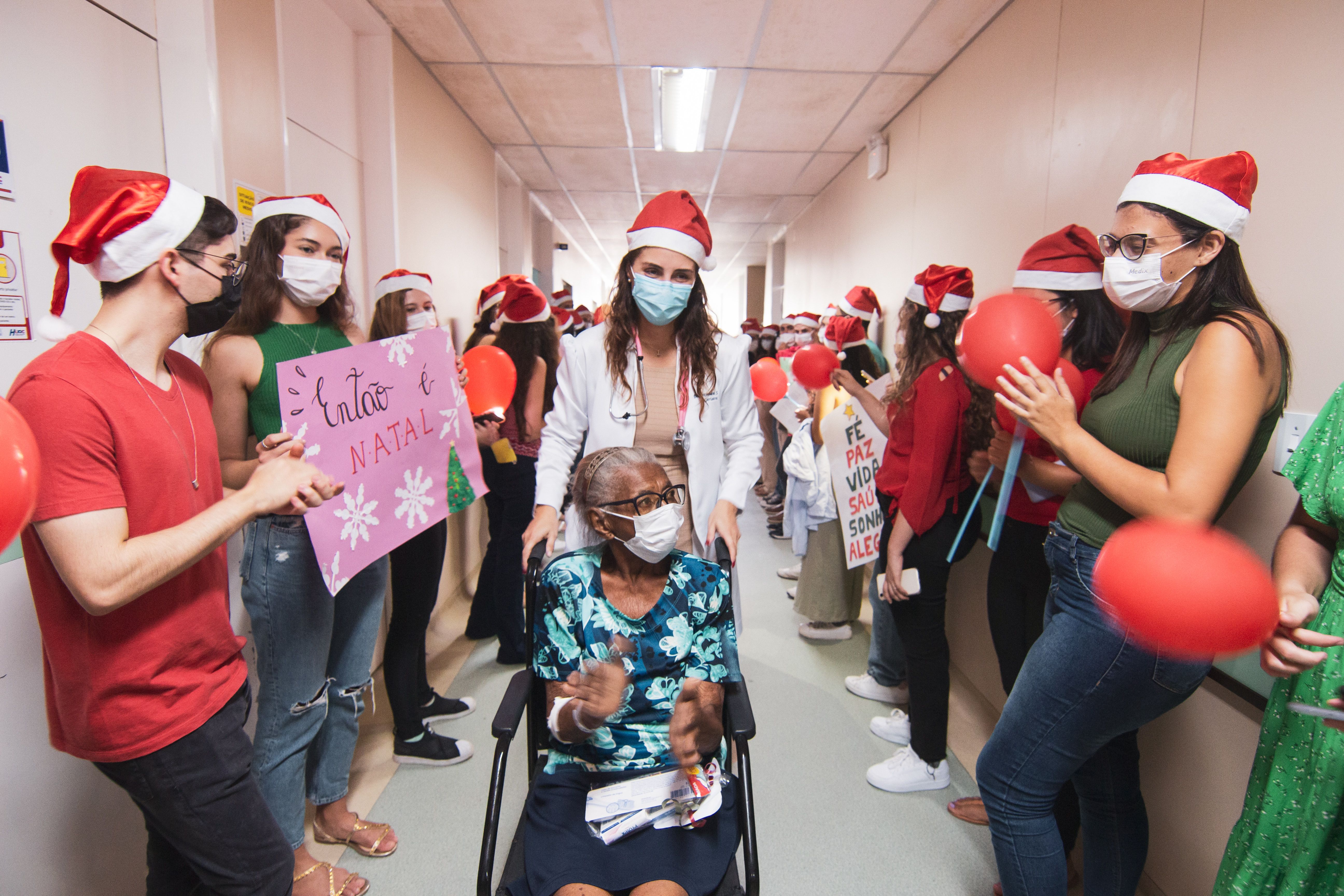A group of people wearing santa hats and holding signs · Free Stock Photo