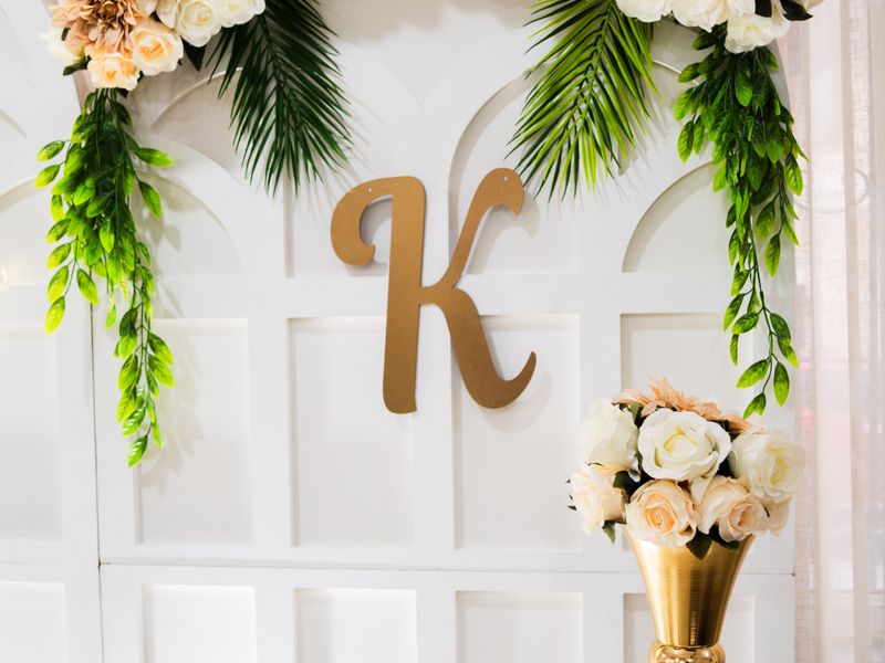 Floral arrangement over a golden letter