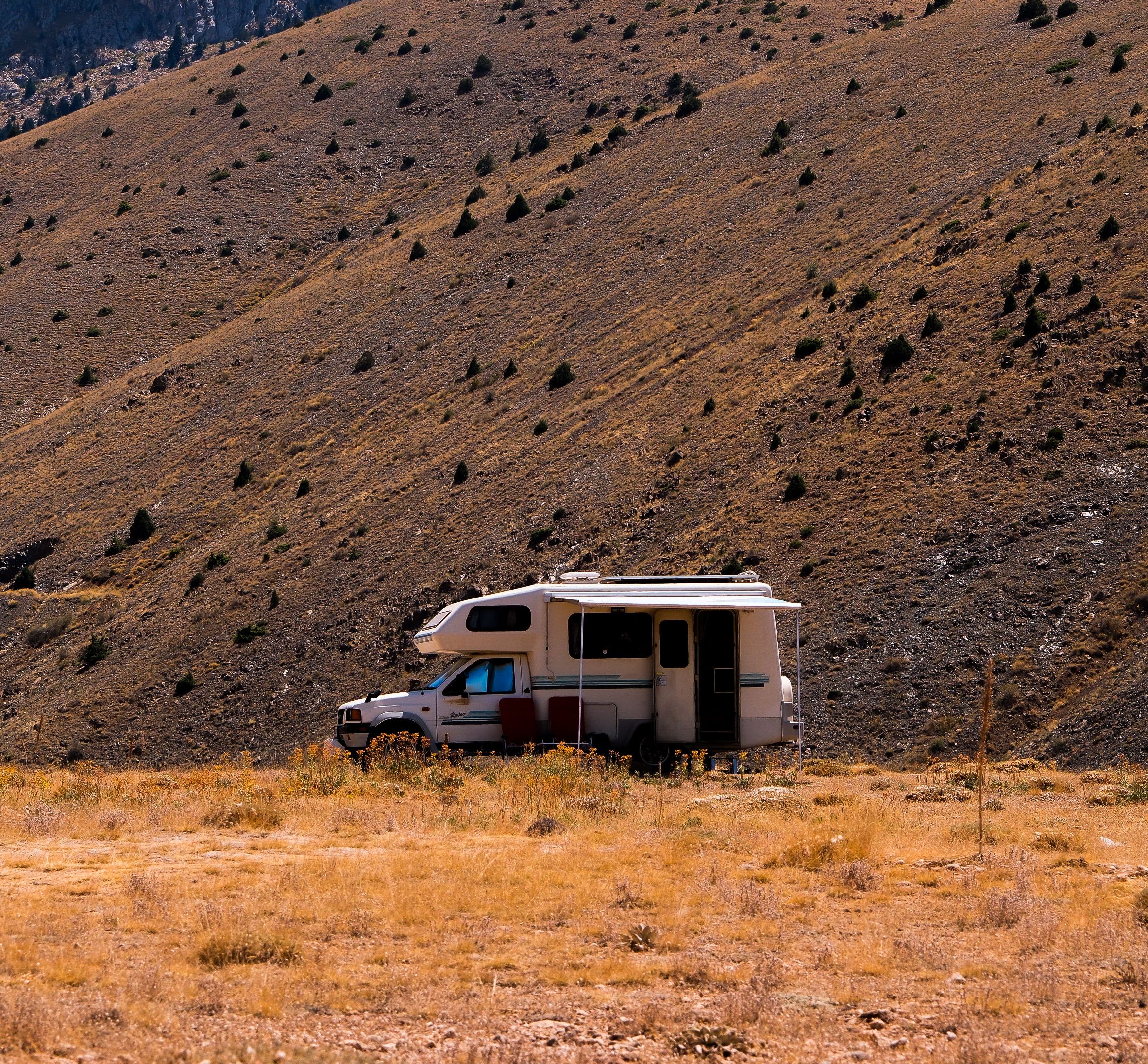 Solitary camper van parked in a dry desert landscape
