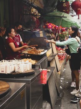 Crowded street food stall in Manila's bustling market, capturing the lively atmosphere.
