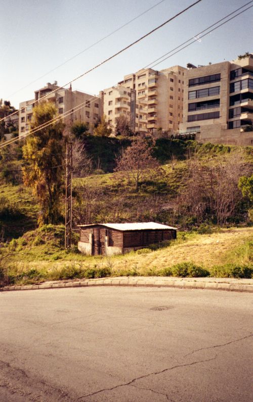 Free Urban scene in Amman showcasing high-rise buildings and an abandoned shack, highlighting contrasting architecture. Stock Photo